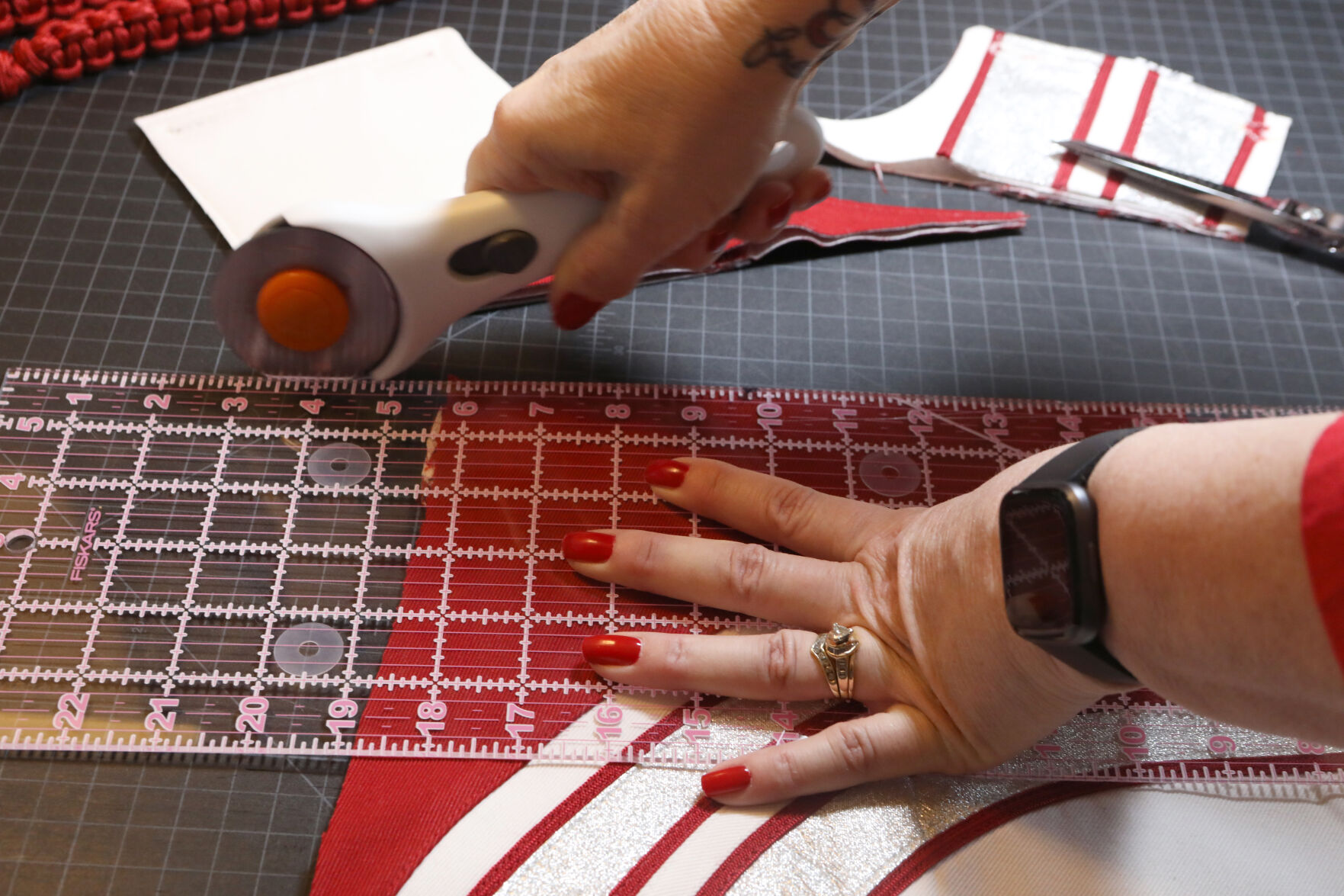 DeAnn Fielder measures and cuts fabric